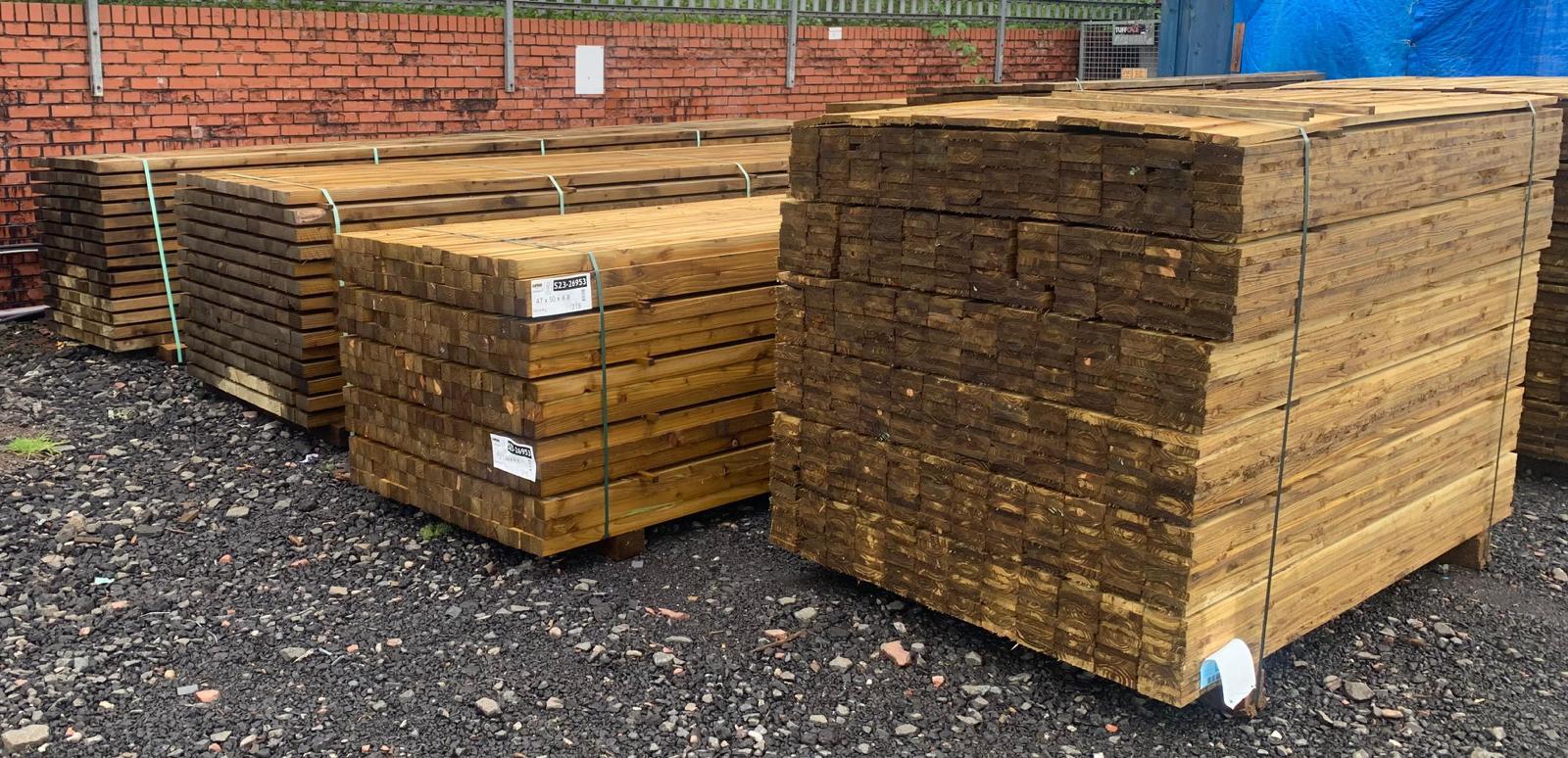 Various packs of treated wooden fencing material.