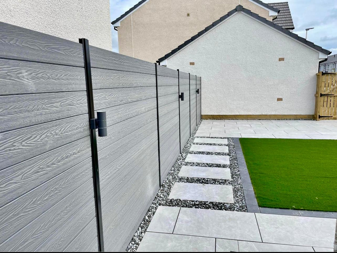 Steel grey composite fence boards with black posts and black down lights.