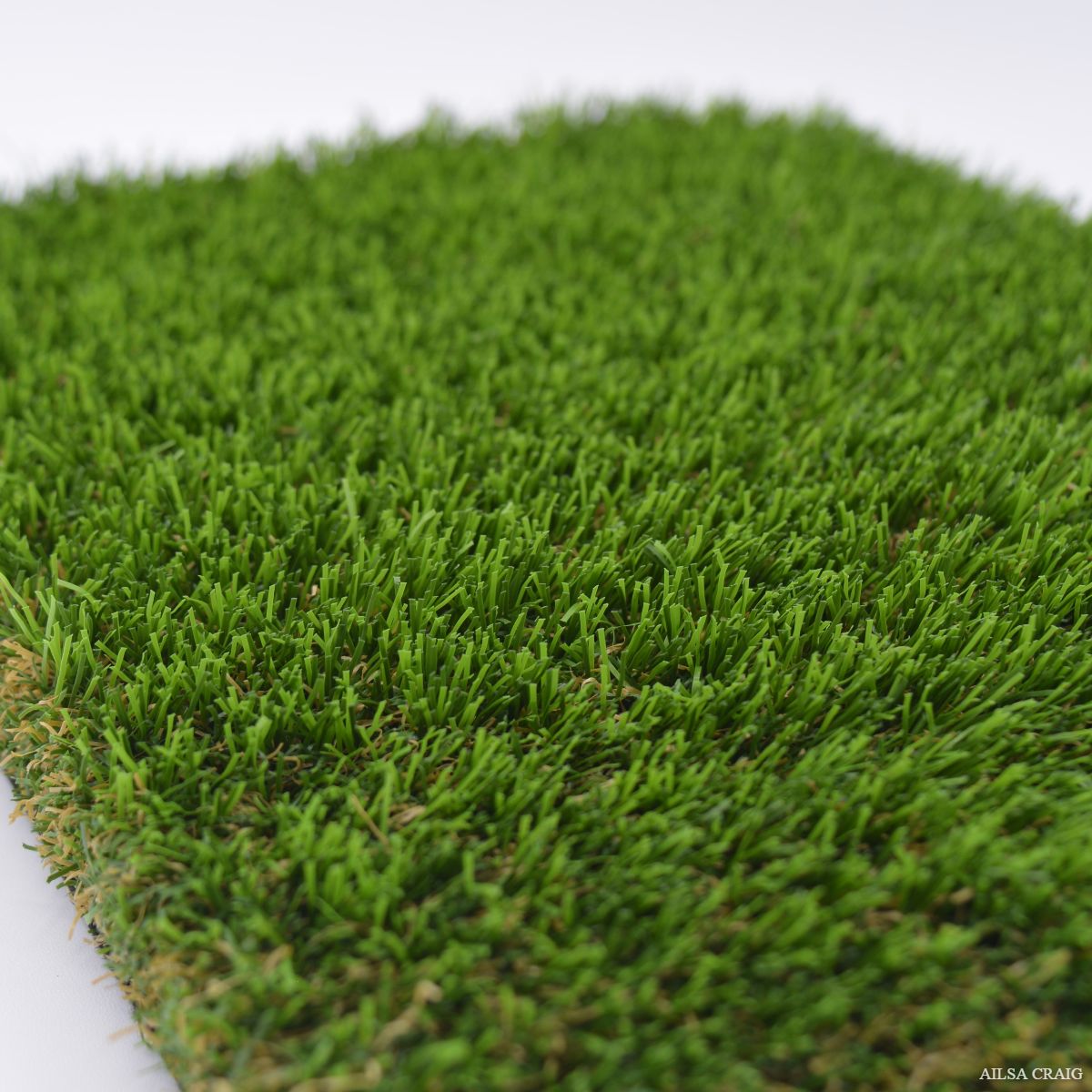 Close-up of artificial grass blades with a white background