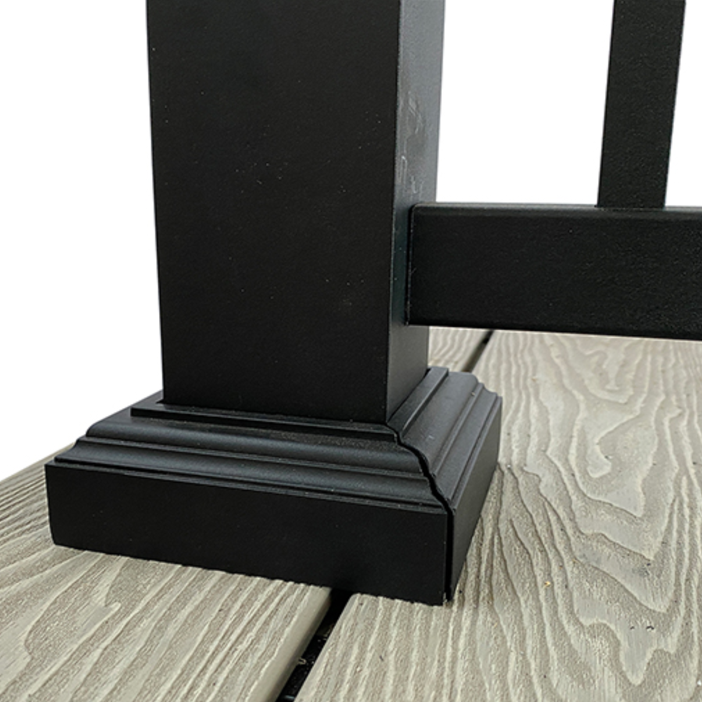 A black aluminium balustrade post foot on oak composite decking.