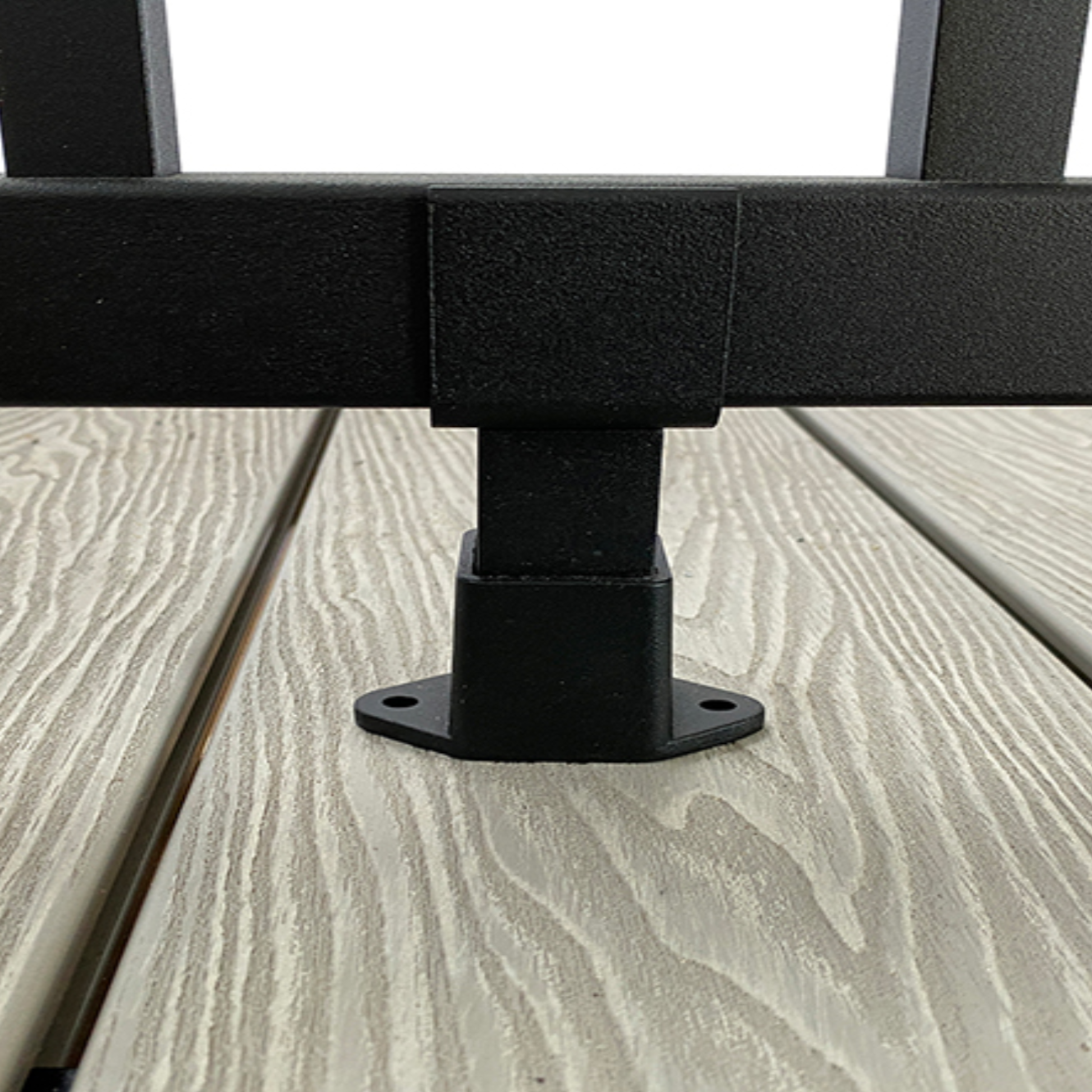 Black aluminium balustrade support foot, on an oak composite decking board.