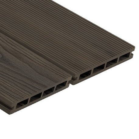 A modern composite decking installation with dark brown, amber wood-like appearance.