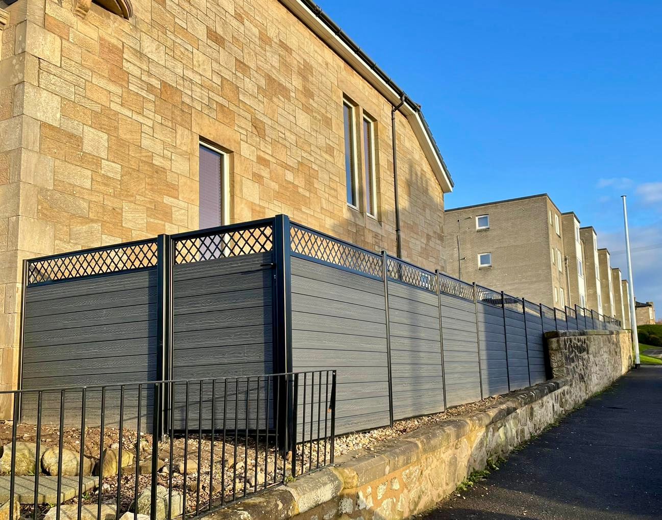 A large anthracite composite fence and gate in Glasgow, with traditional style fence topper.