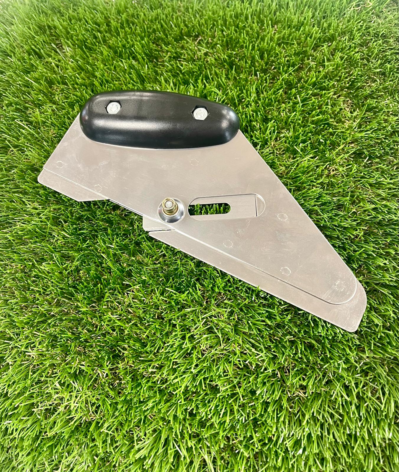 A black and silver cushion back knife used to cut straight lines in fake grass.