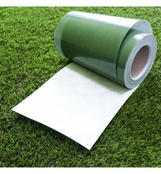 A green and white roll of artificial grass joint or seem tape partially rolled out on top of artificial fake grass.