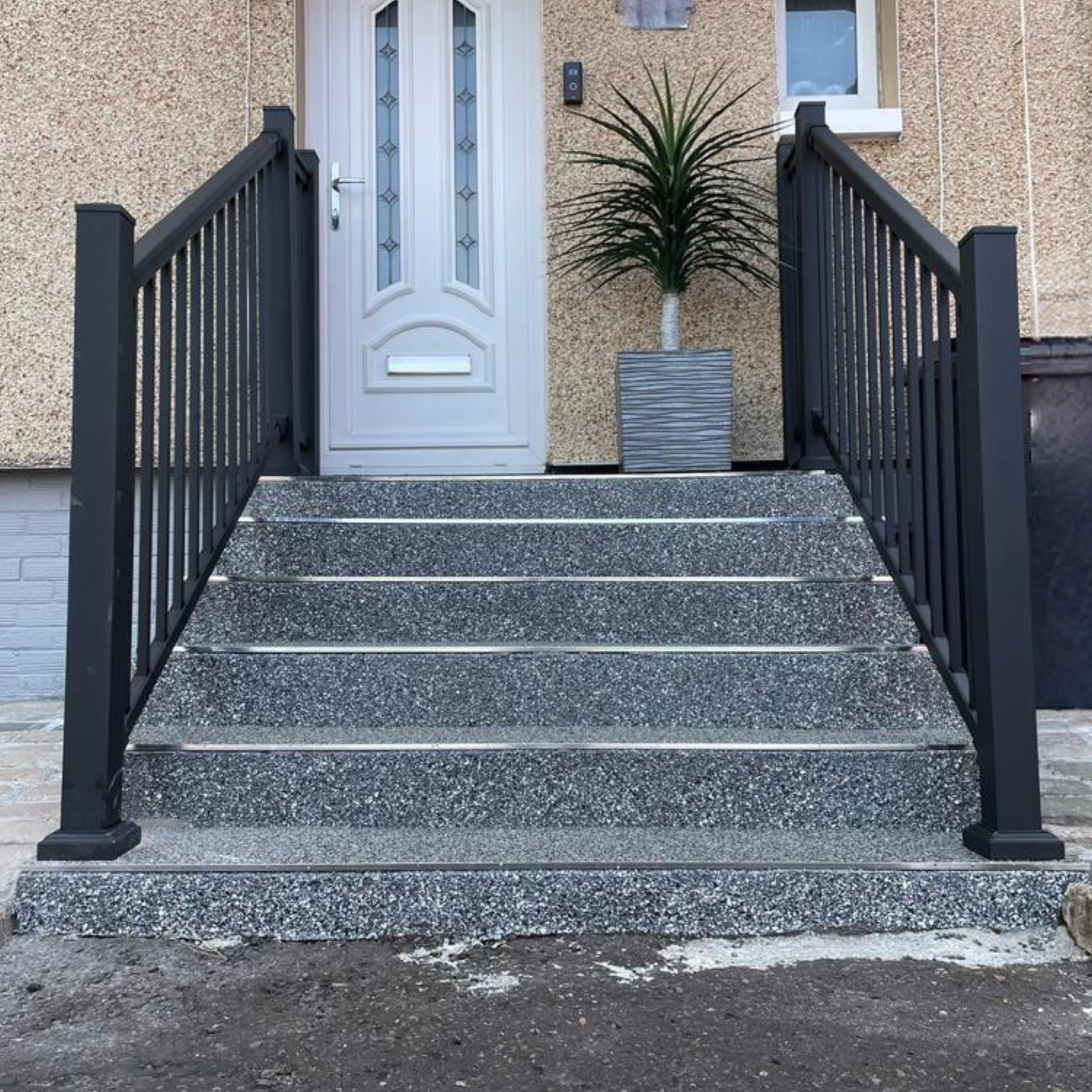 Black aluminium handrail balustrade installed on both sides of a set of steps.