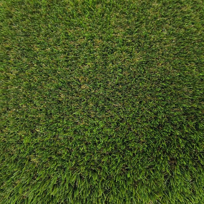 Square piece of artificial grass on a white background