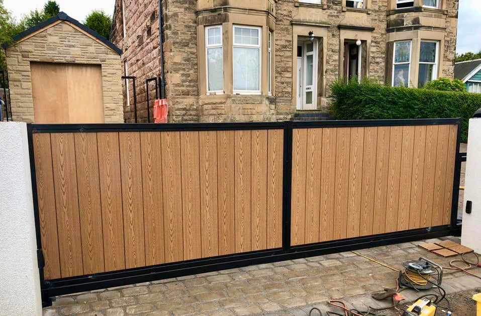 A set of 4ft high 3m wide driveway gates with a light oak composite infill and black galvanised and powder coated frame.