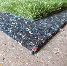 Artificial fake grass laid on top of black underlay shock pad.