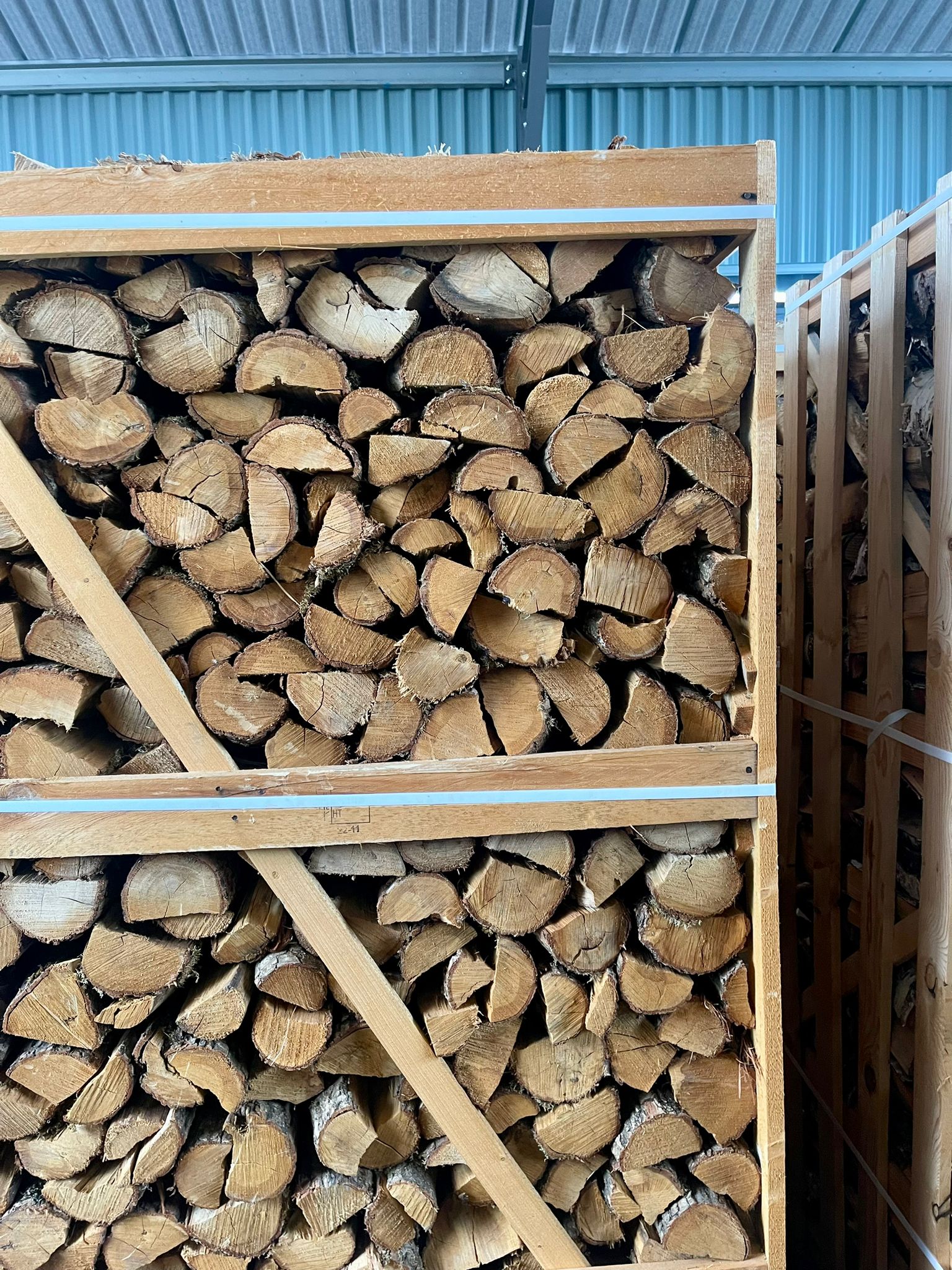 A picture of several large crates of kiln dried silver birch firewood logs.