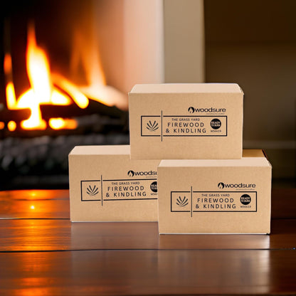 Three 500g boxes of firelighters sitting on a table with an open fire in the back ground.