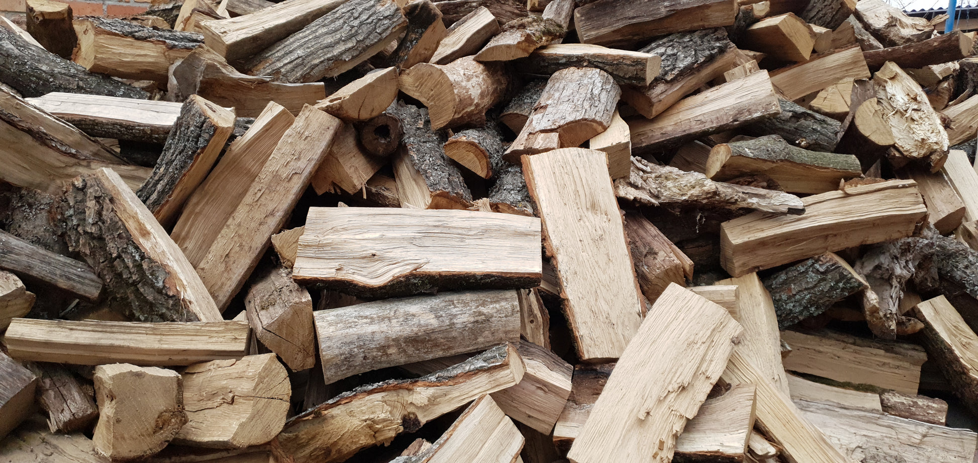 A large pile of oak firewood logs.