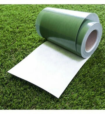 A roll of artificial grass joint tape unrolled on one end, displayed on a grass surface.
