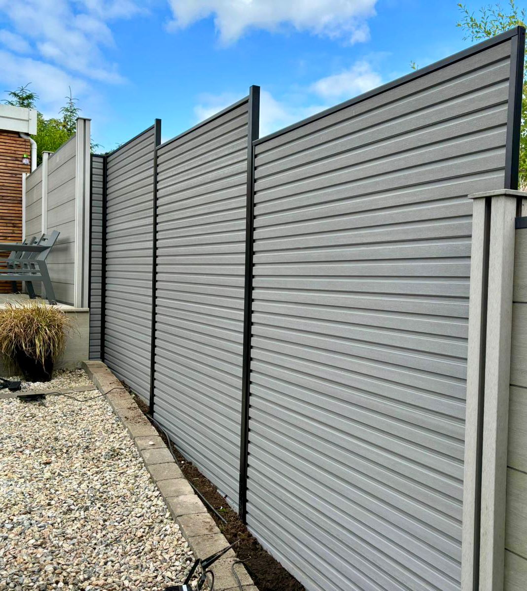 Slatted composite fencing in steel grey with black posts between two back gardens.