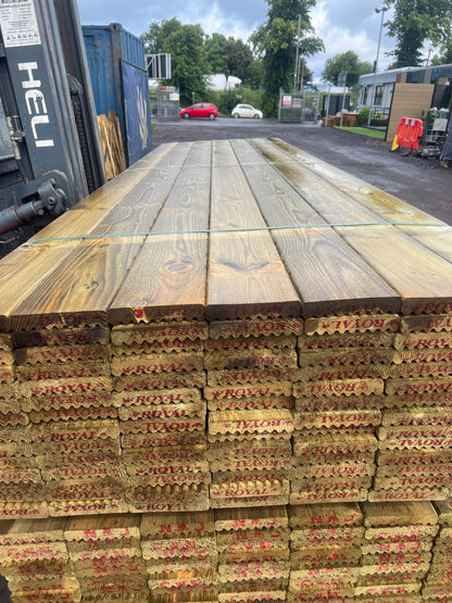 A forklift carrying a pack if wooden decking boards.