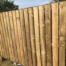  a 6ft high wooden slat and rail fence in light brown.