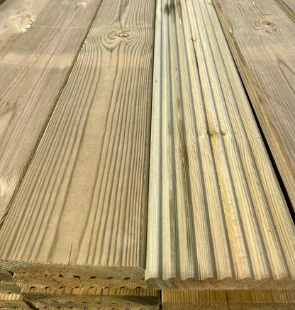 Treated wooden decking boards smooth on one side grooved n the other.