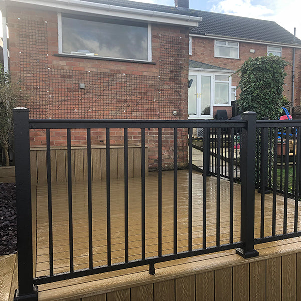 A picture Grass Yard aluminum balustrade in black installed on a brown composite decking.