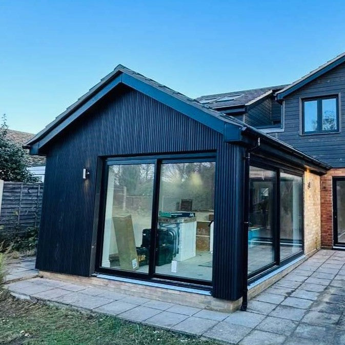 House extension clad in back composite shadow cladding.
