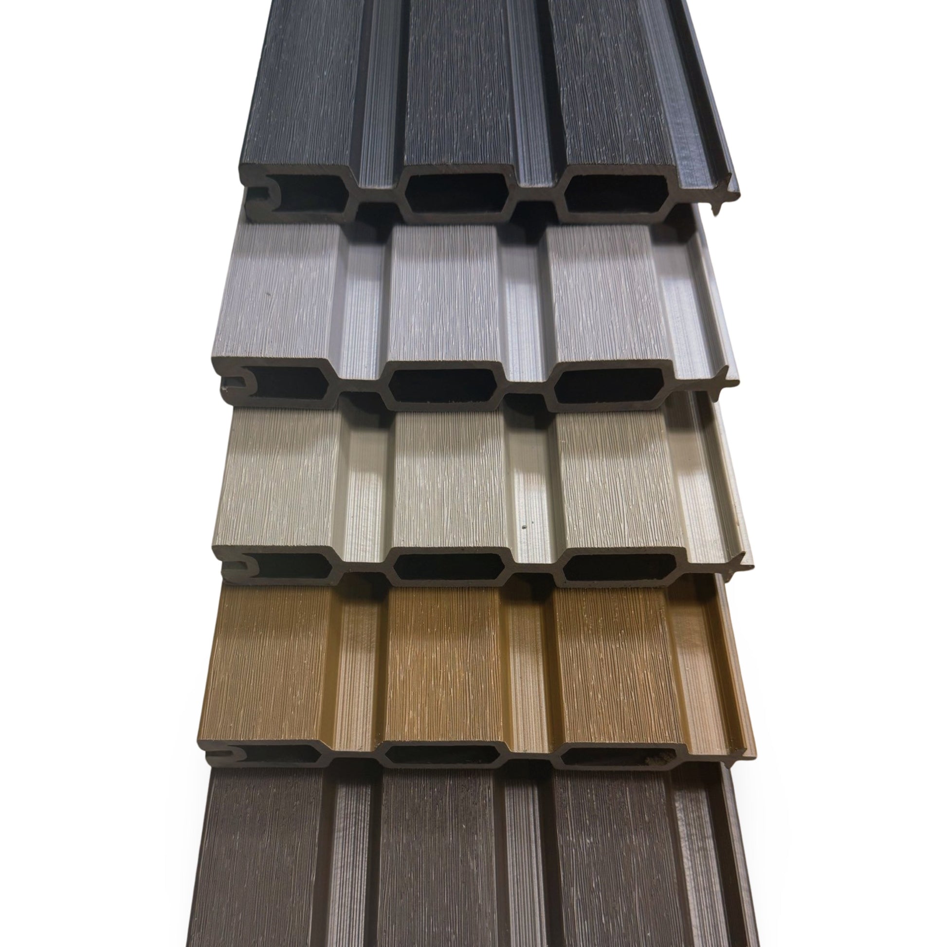 A collection of different coloured slatted fence boards stacked neatly in a pile showing the end profile, shape and colour.